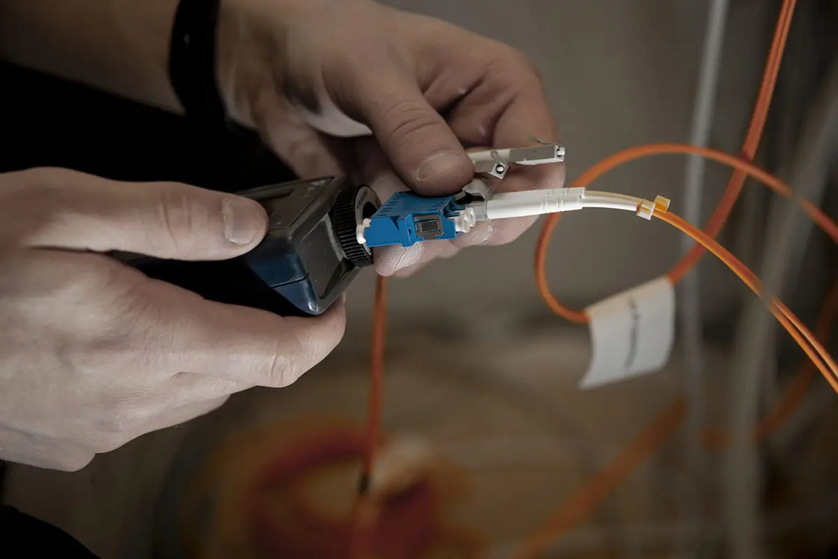 Installatör arbetar med fiberoptisk kabel under bredbandsinstallation