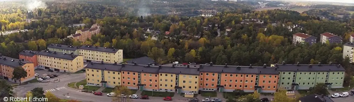 Flygfoto över BRF Botkyrka i Tullinge med flerbostadshus omgivna av grönska och bostadsområde.