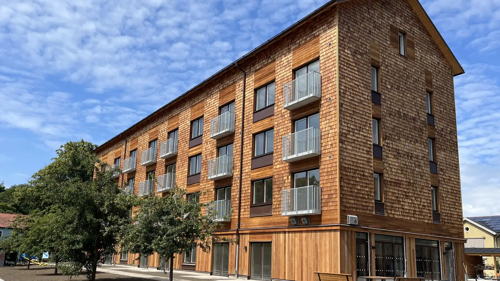 Flerbostadshus i trä med balkonger, en av Trianons hyresfastigheter.