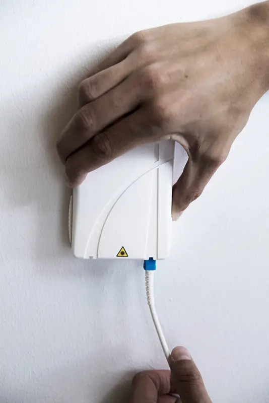 Blå fiberkontakt korrekt isatt i fiberuttag med kabel nedåt.