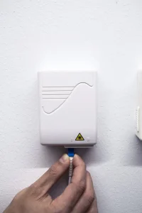 Blå fiberkontakt förs in i fiberuttag efter att plasthållaren tagits bort.