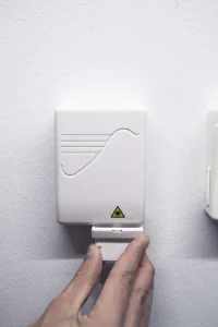 Hand som skjuter tillbaka plasthållaren för att hålla kabeln på plats.