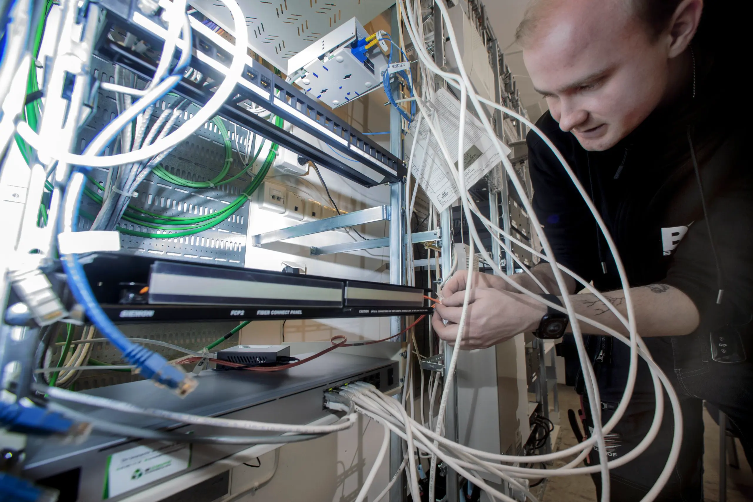 Närbild på Bahnhof-tekniker som installerar fiberkablar för colocation.