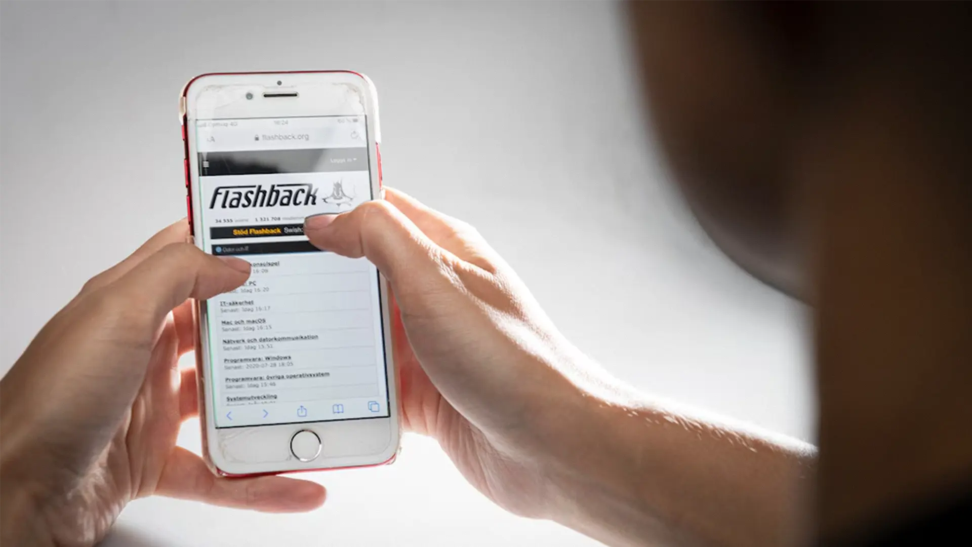 Person använder forumet Flashback i en mobiltelefon.